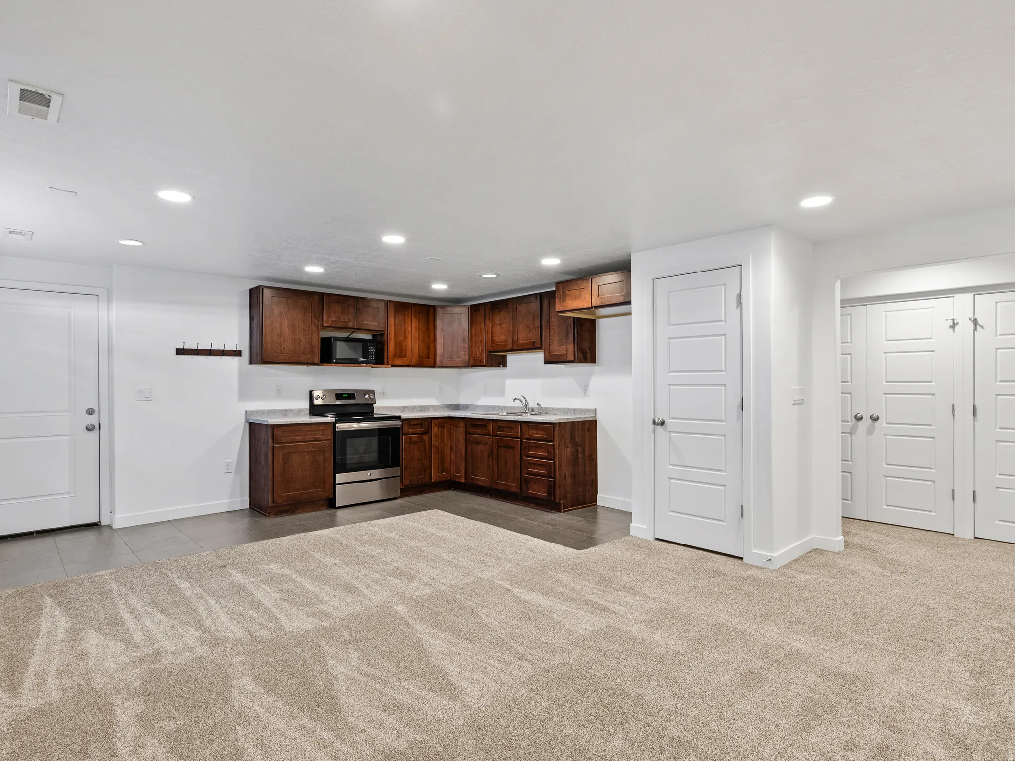 Functional kitchen area featuring rich wood cabinetry, stainless steel appliances, and a light-toned countertop
