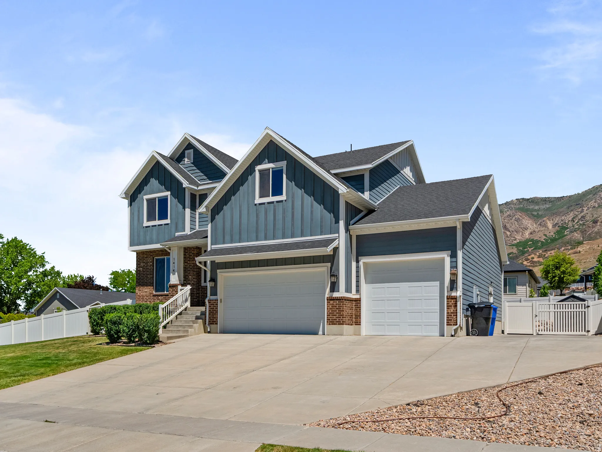 Contemporary two-story residence featuring a blue siding and brick exterior