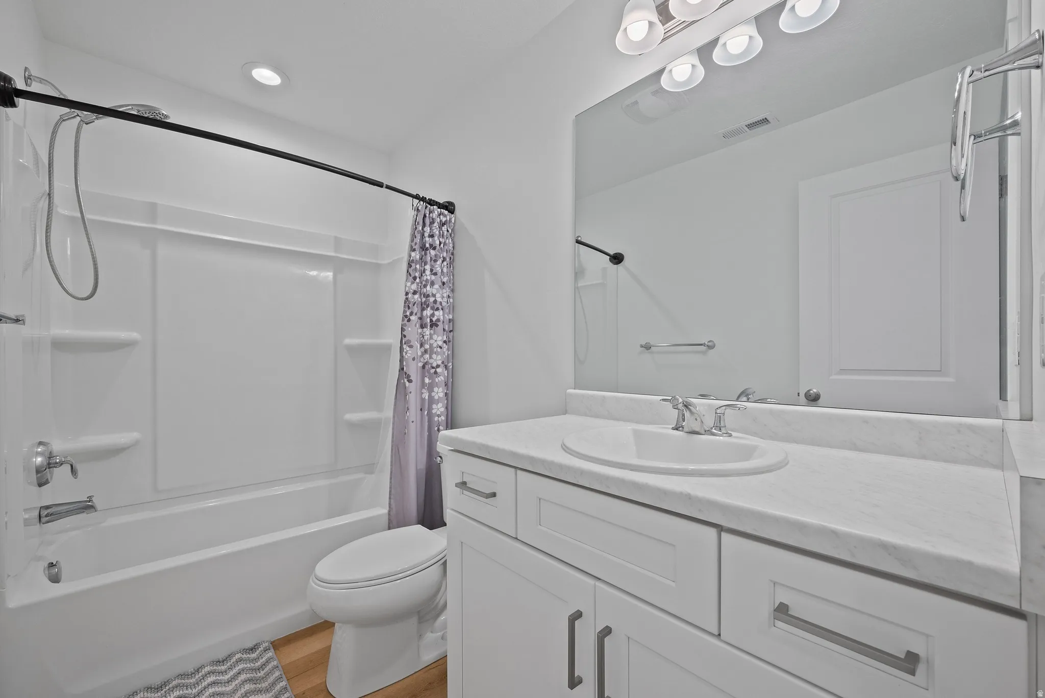 Bathroom featuring a white vanity with shaker-style cabinetry, a white countertop, and a white undermount sink