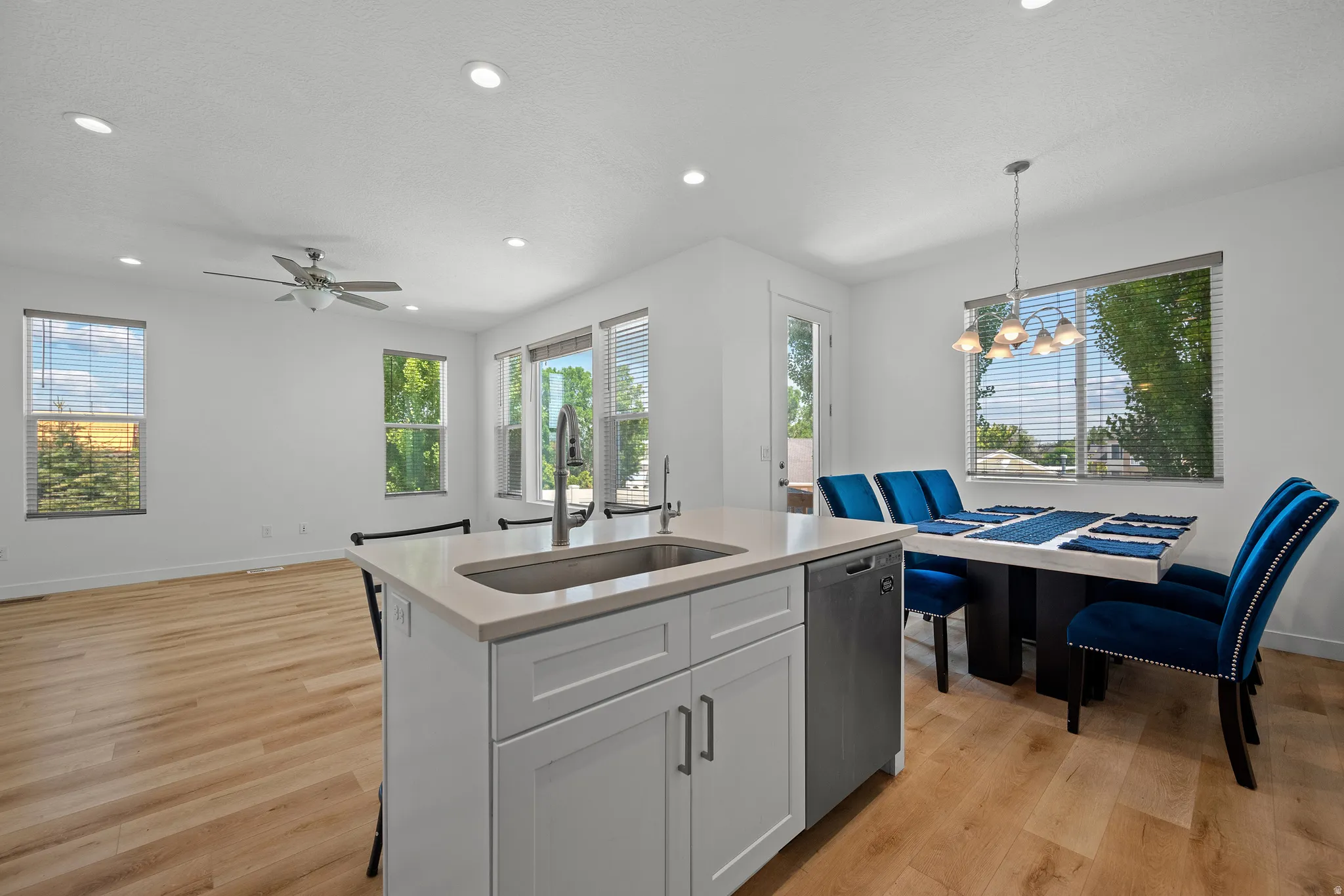 Open-concept living space featuring wood-finish flooring, recessed lighting, and a contemporary ceiling fan