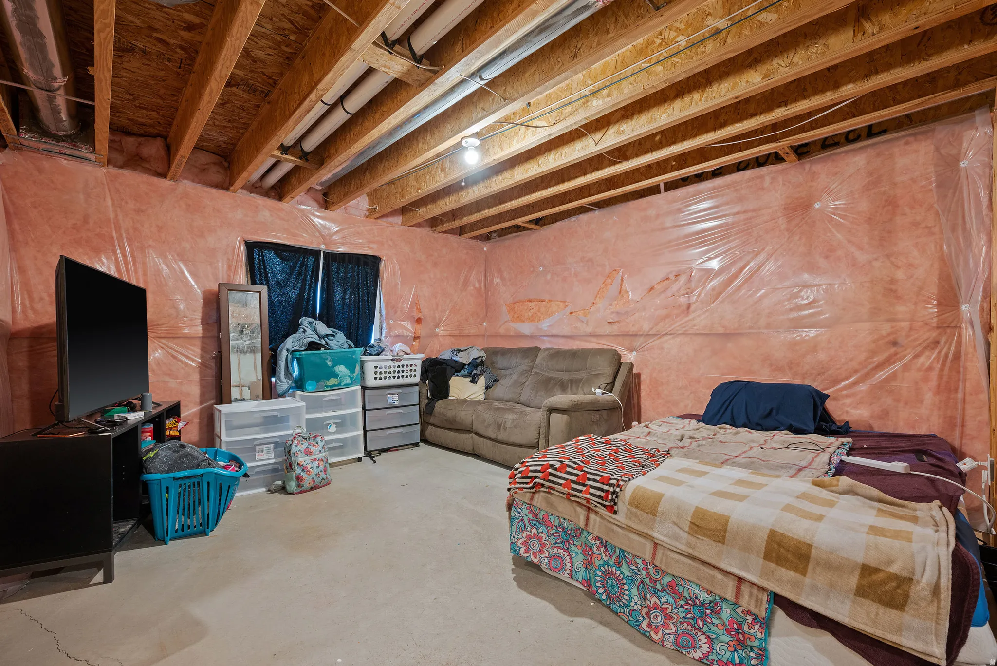 Unfinished basement with exposed ceiling joists and concrete flooring