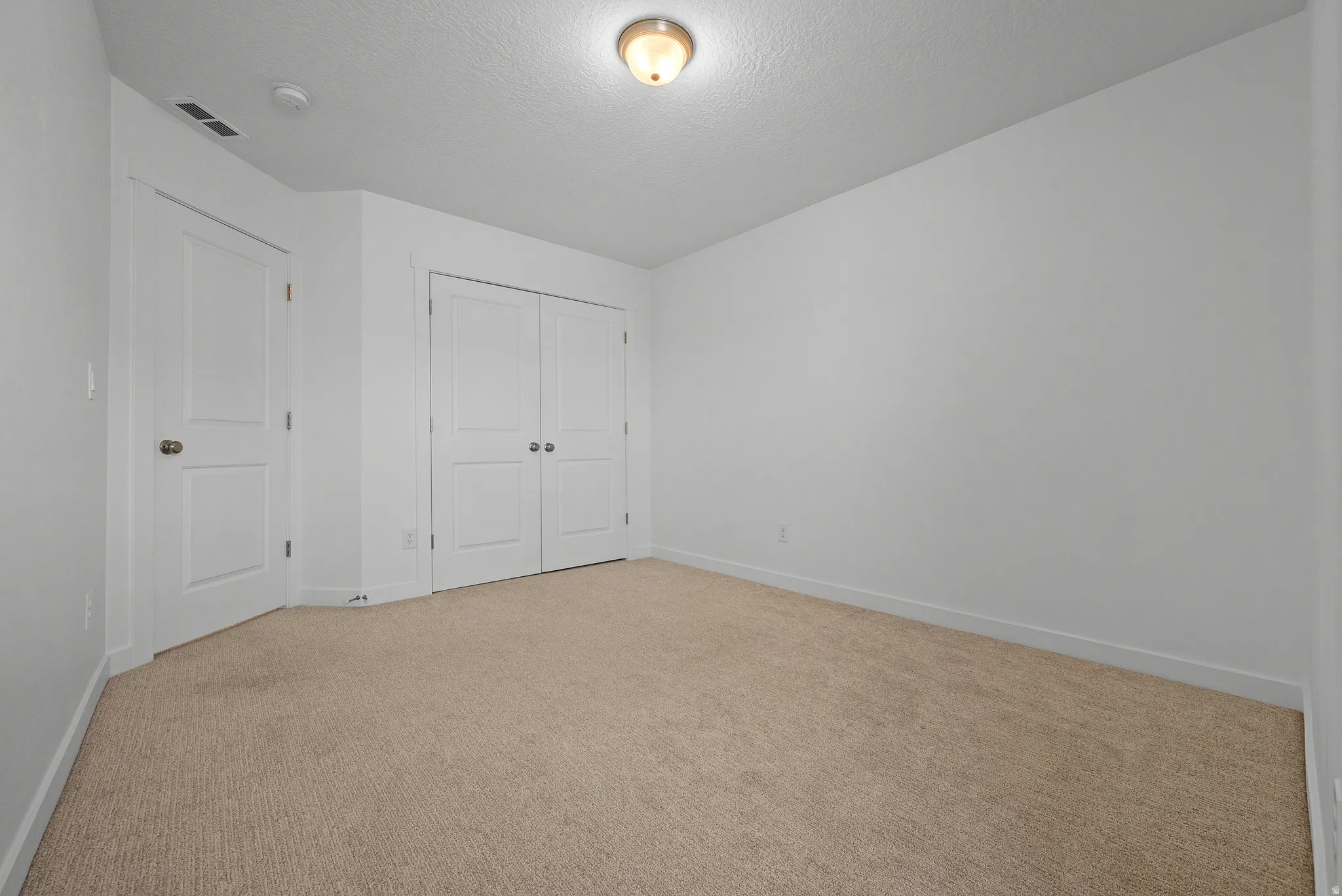 Neutral carpet flooring extends through this room featuring white walls and trim