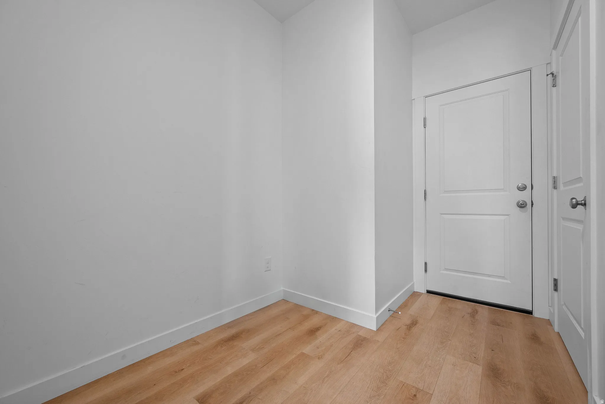 Light wood-finish flooring complements crisp white walls and baseboards