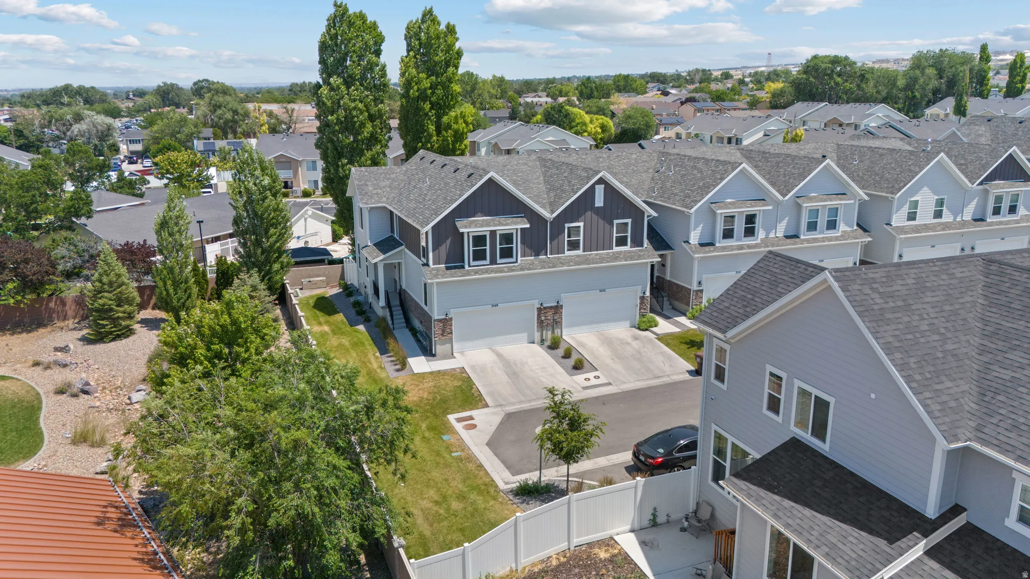 Modern townhome community featuring multi-level residences with attached garages and paved driveways