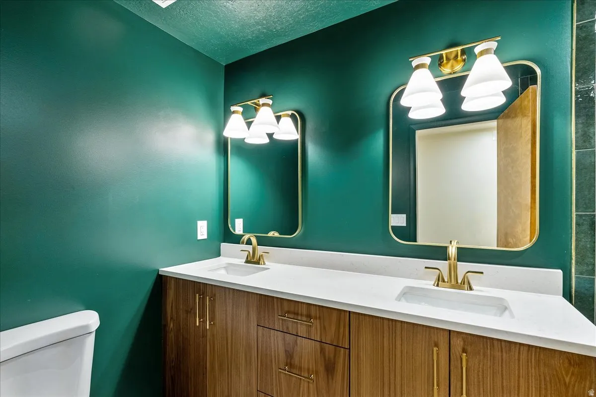 Dual vanity with wood-finish cabinetry and brass hardware