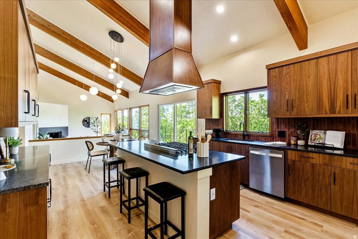 Kitchen featuring wood-finish cabinetry, black countertops, and stainless steel appliances