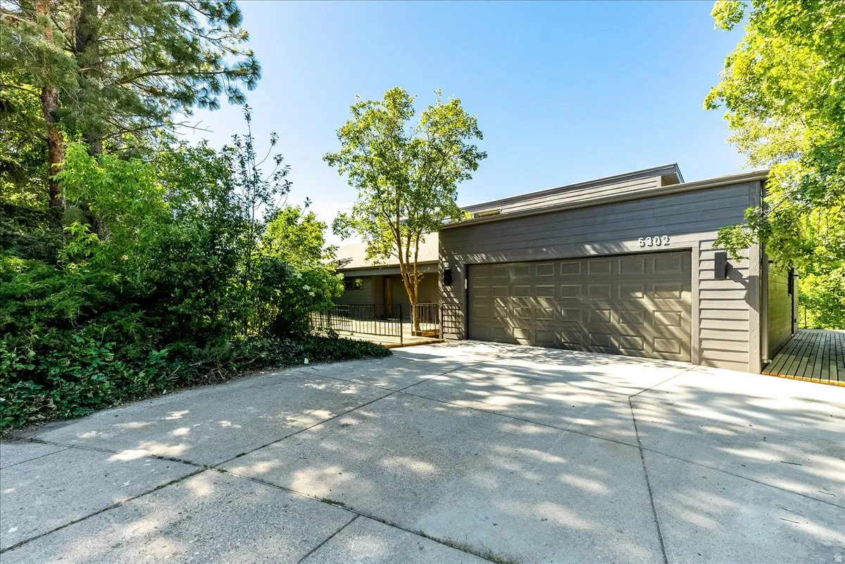Contemporary exterior with gray horizontal siding, a two-car garage, and a concrete driveway