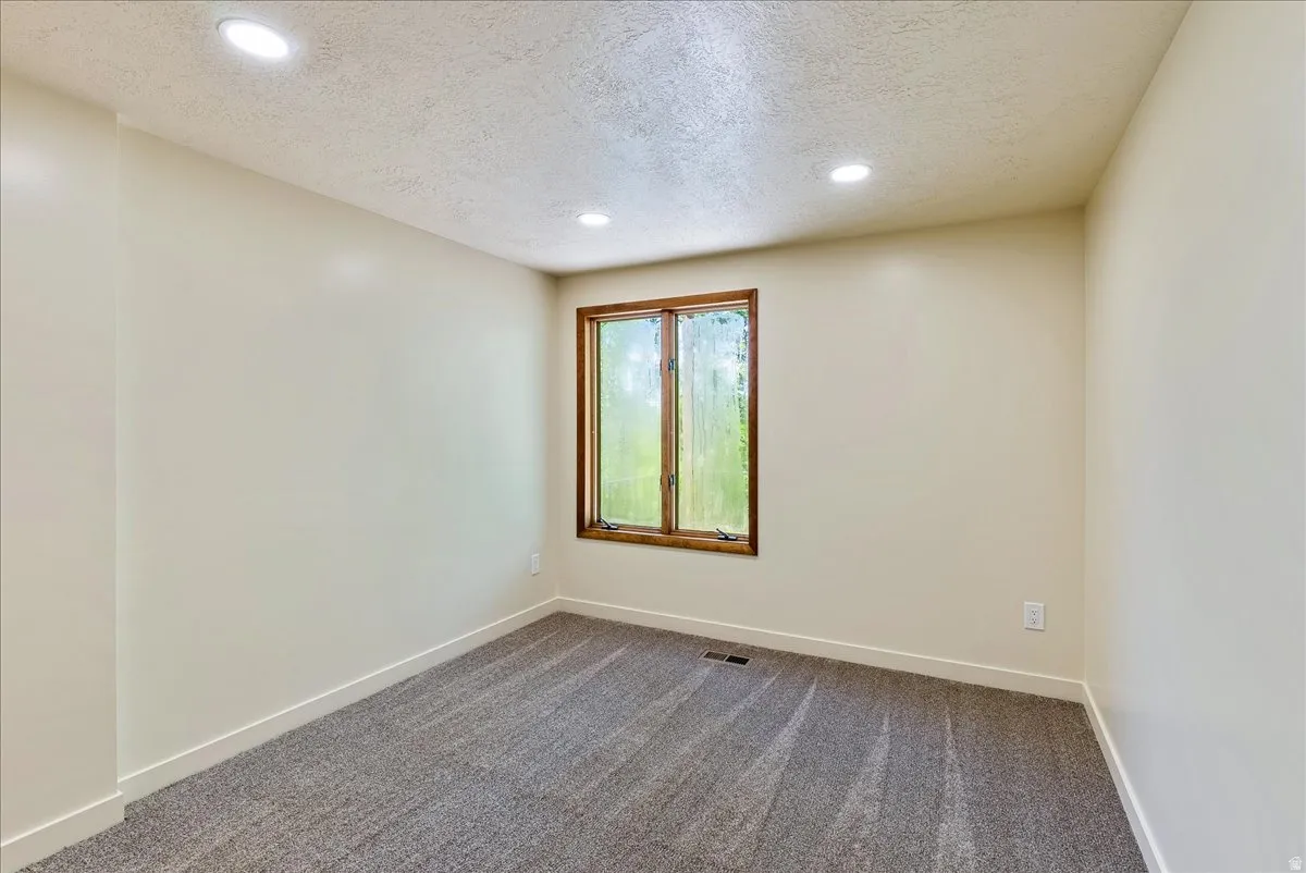 Neutral-toned walls complement the gray patterned carpet flooring