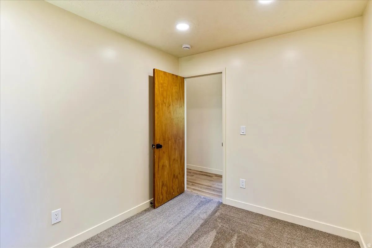 Wall-to-wall carpeting with light beige walls and white trim