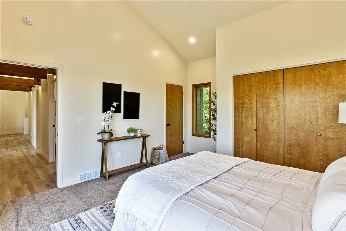 Vaulted ceiling bedroom featuring carpeting, built-in bi-fold closet doors, and recessed lighting