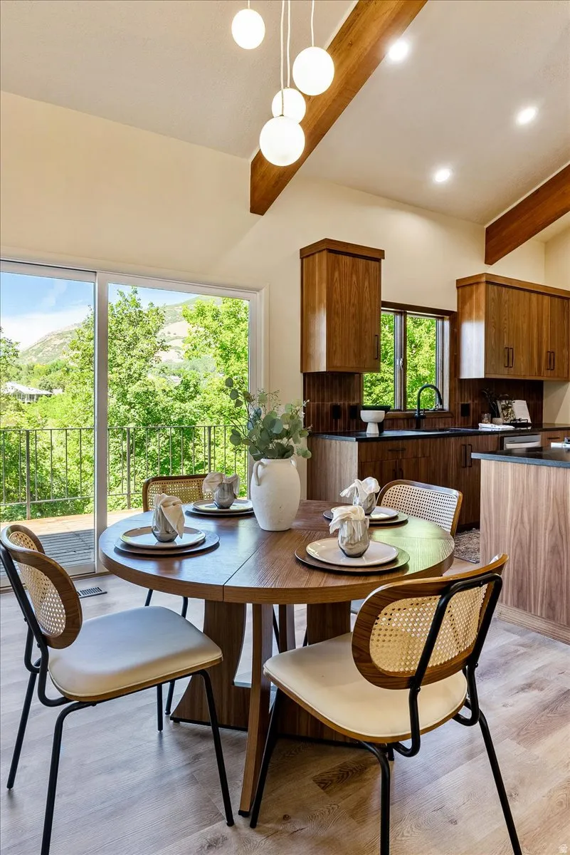 Dining area with wood-finish flooring and a contemporary globe pendant light fixture