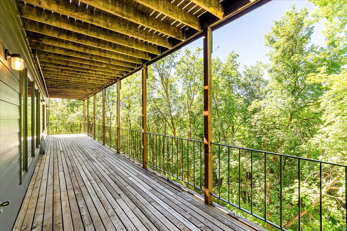 Expansive wooden deck featuring horizontal plank flooring and a black metal railing