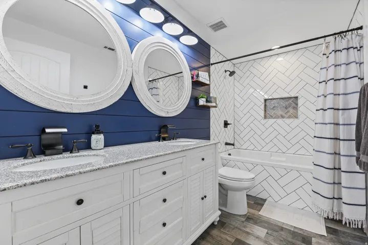 Large basement full bath with lovely tile work and double sinks