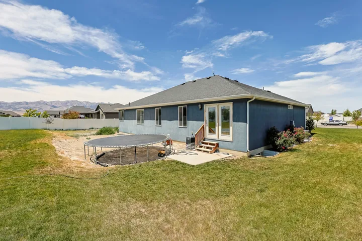Rear exterior, french doors leading out to an expansive backyard.