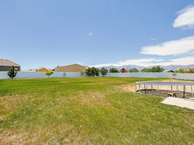 Large backyard with a large grassy area. Beautiful vinyl fencing on three sides.