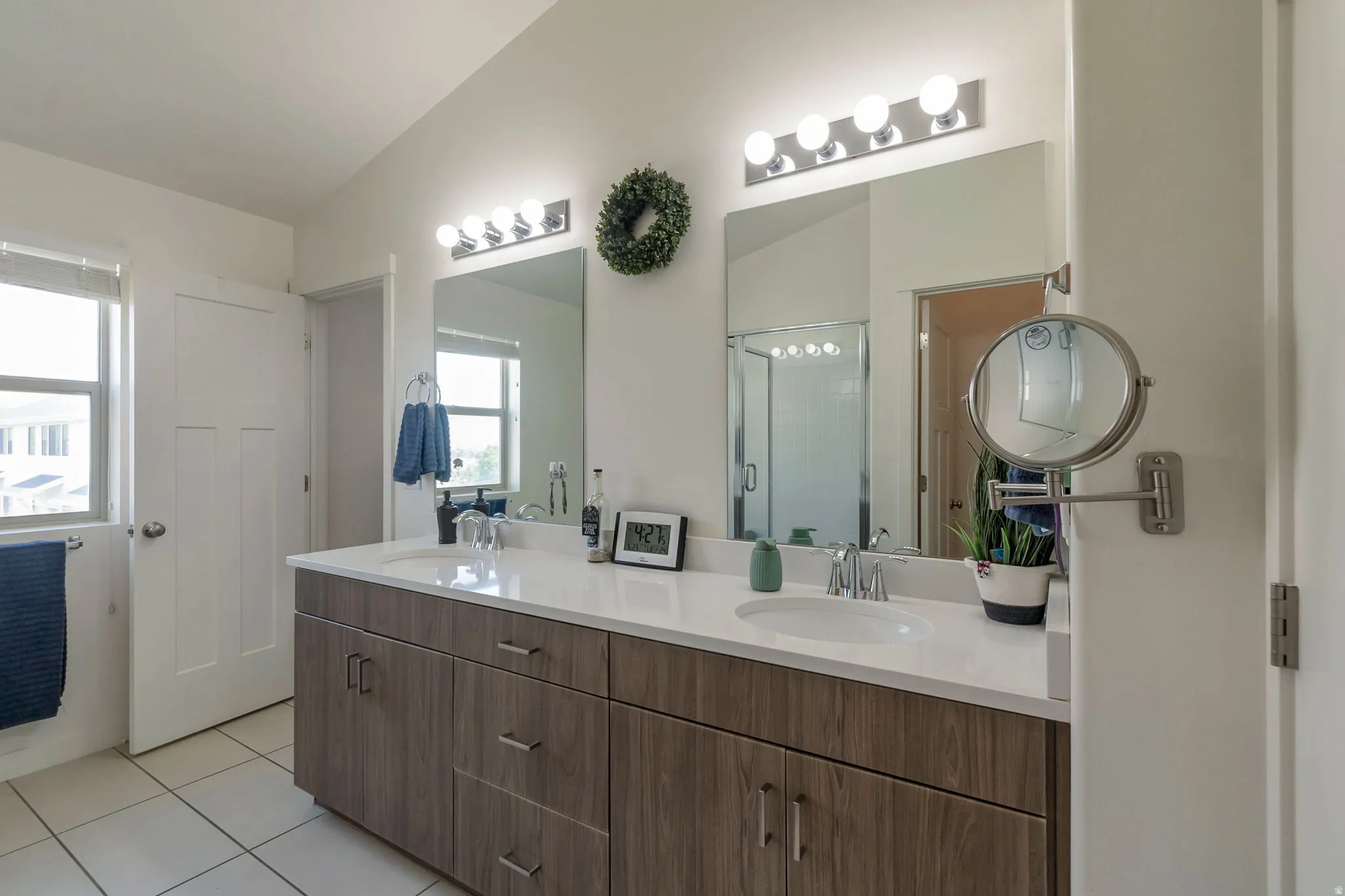 Bathroom featuring a double vanity with wood-finish cabinetry, white countertop, and dual integrated sinks