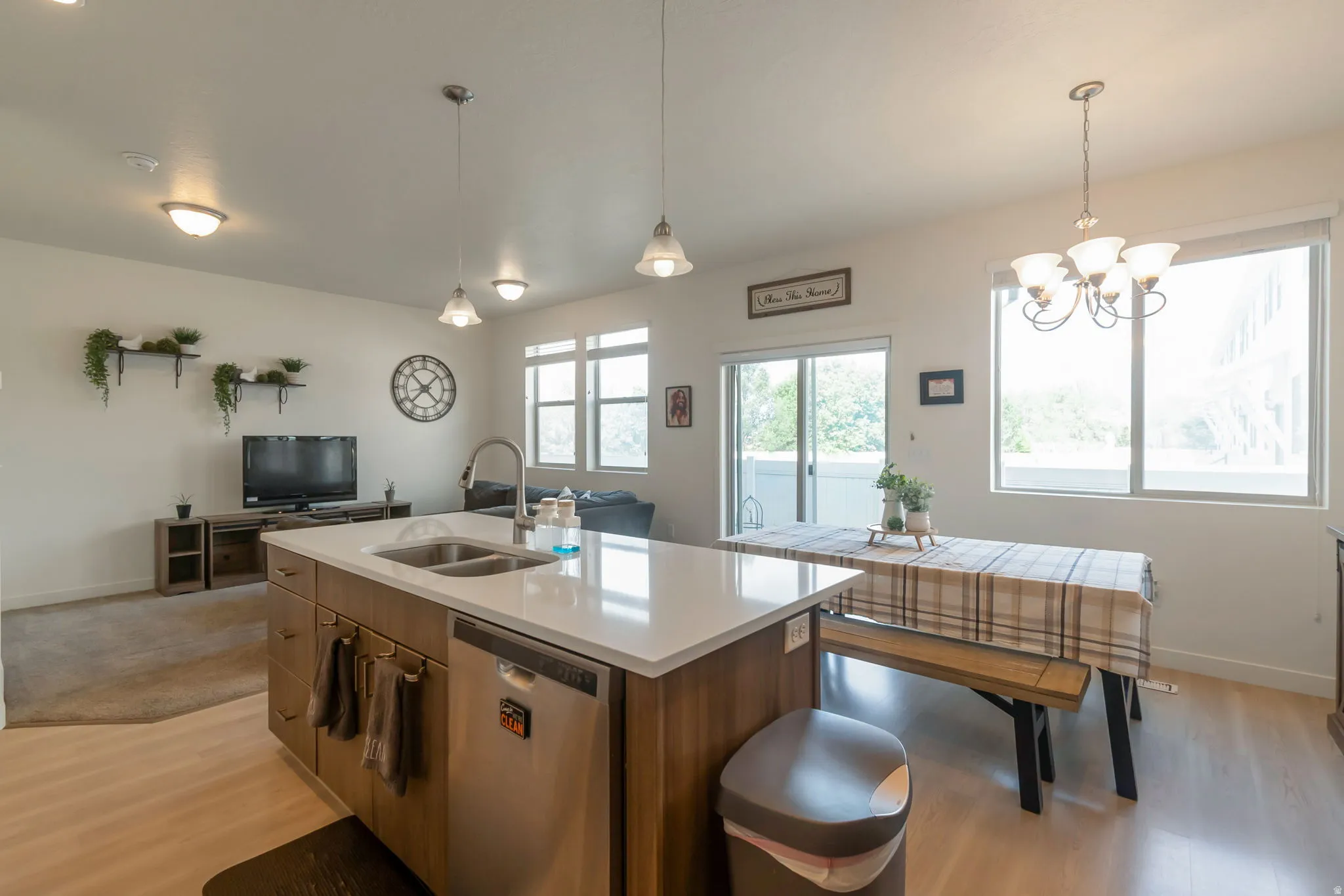 Open-concept living space featuring a central island with a double basin sink and stainless steel dishwasher