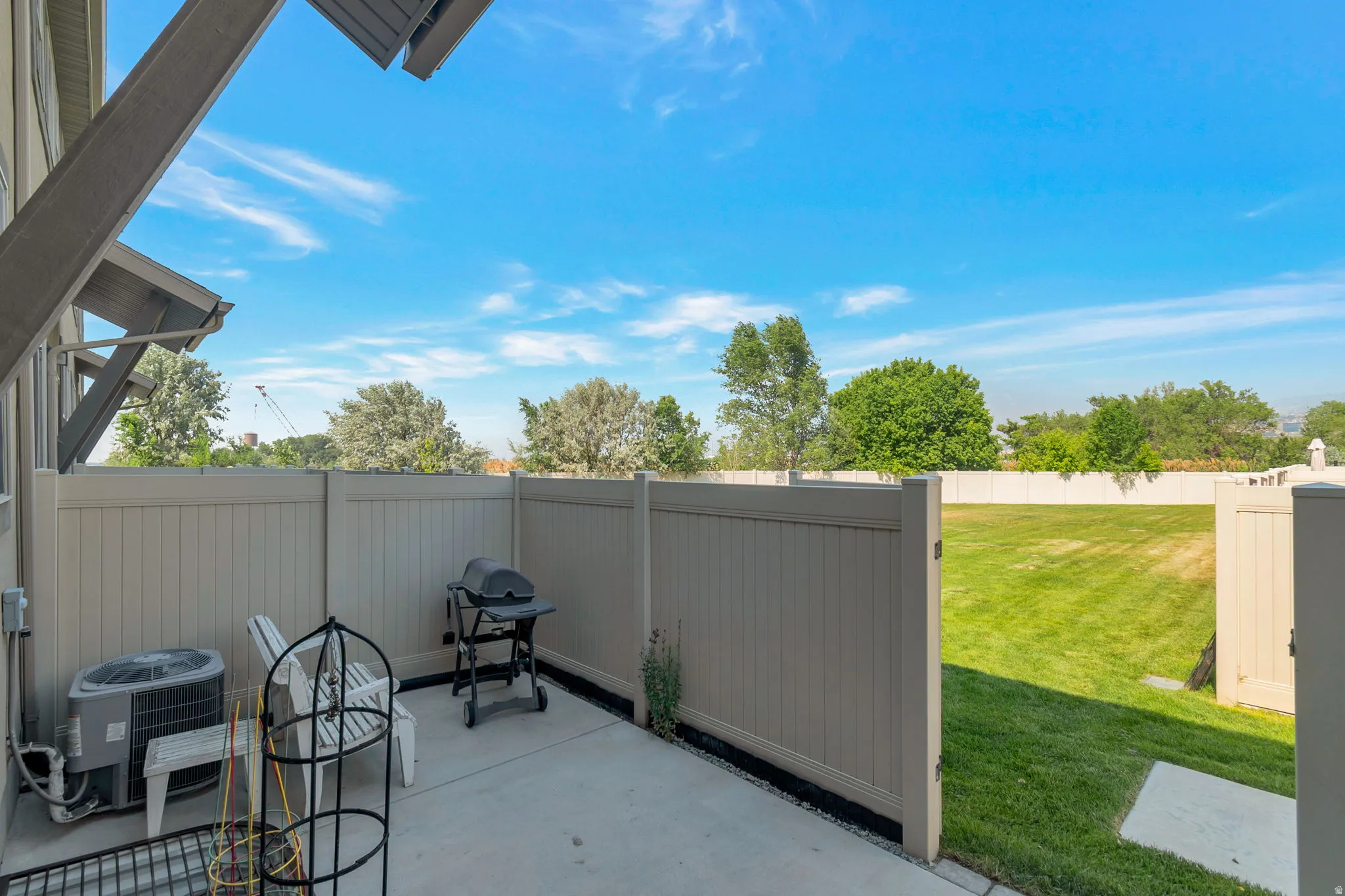 Private patio space featuring a concrete slab and vinyl privacy fencing