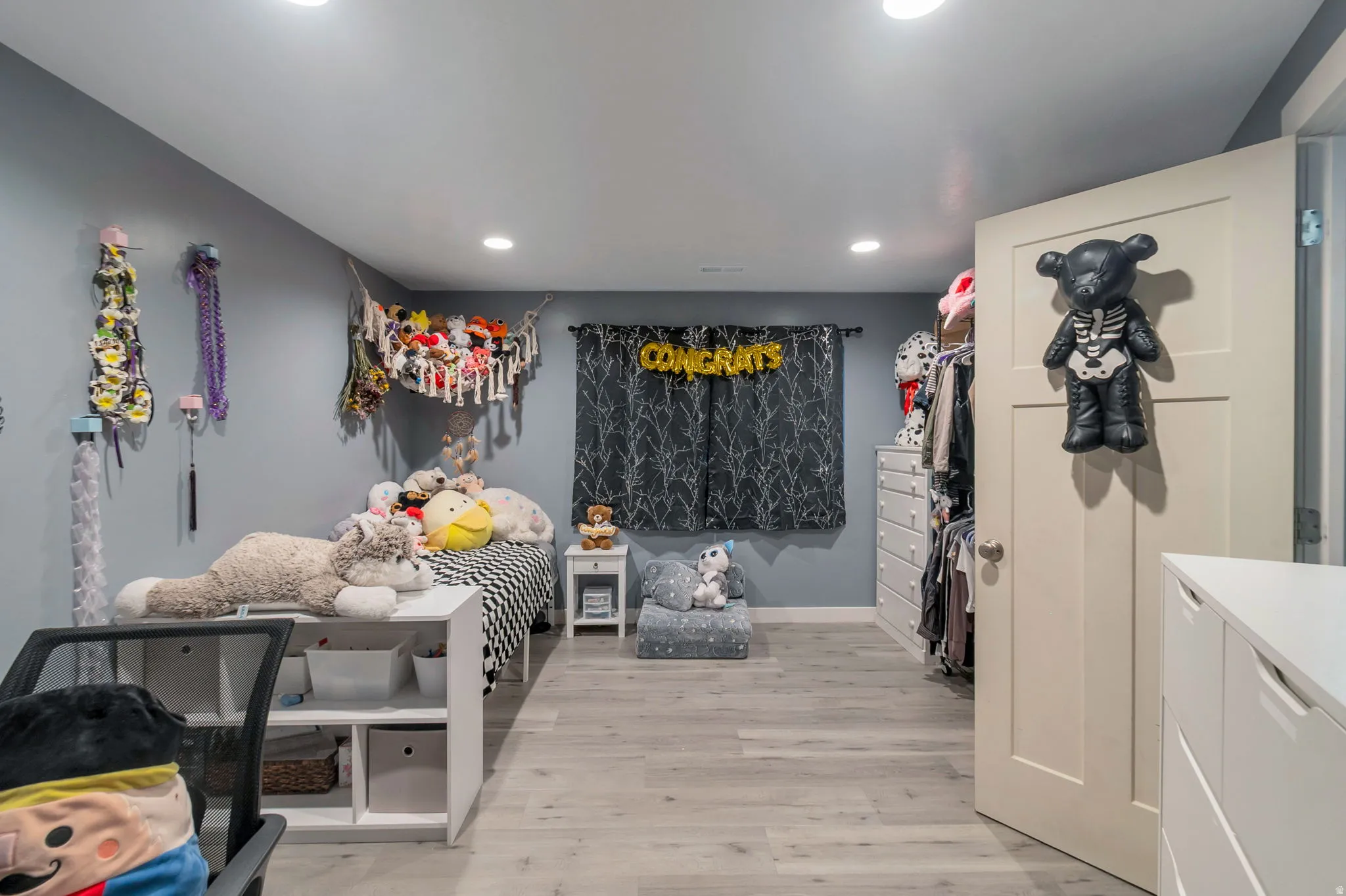 Interior room featuring recessed lighting, light wood-finish flooring, and a flat-panel door