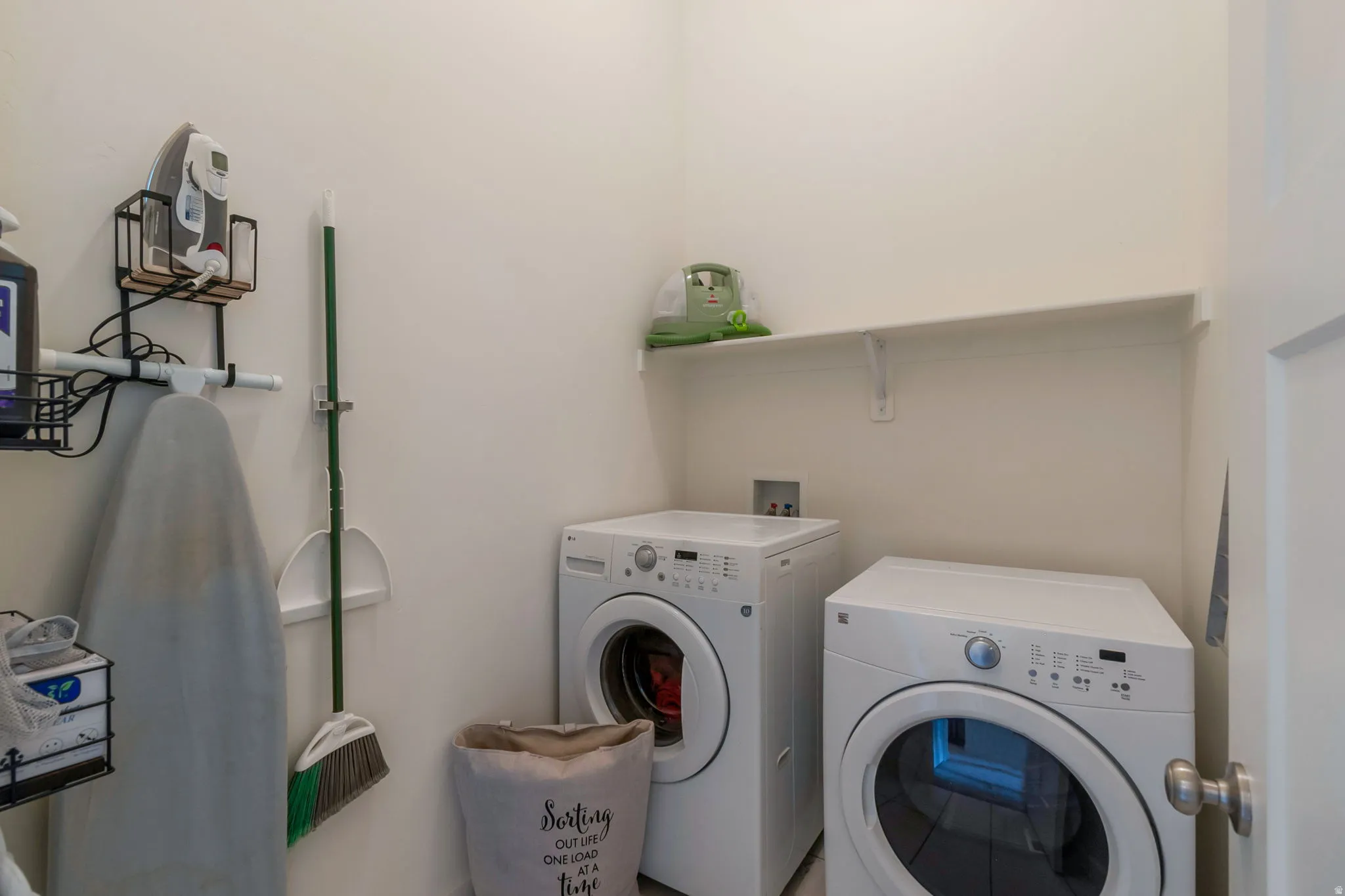 Dedicated laundry area featuring white walls and a single wall-mounted shelf