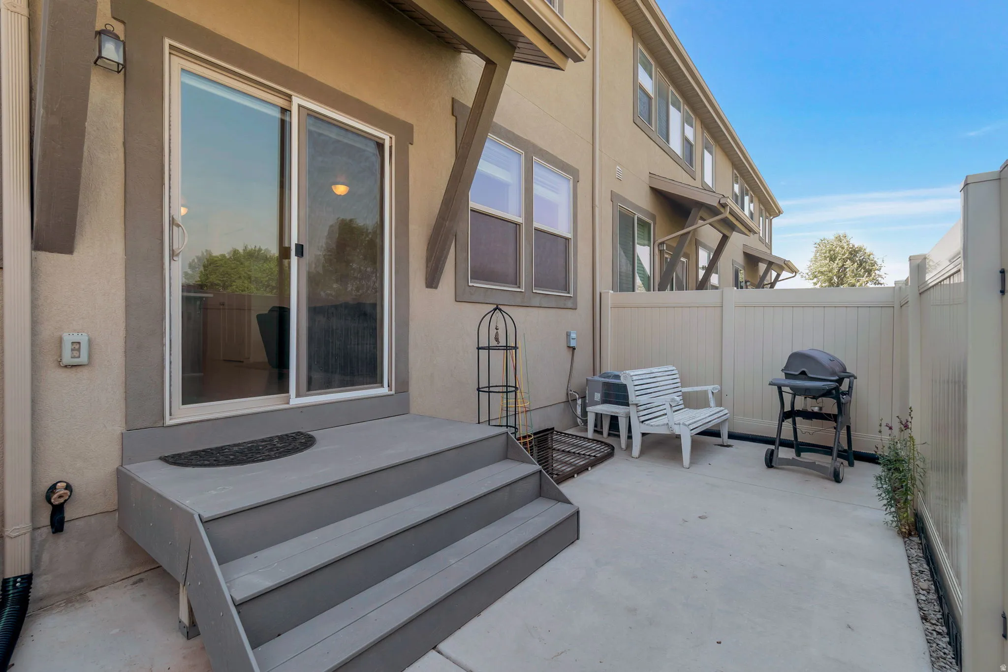 Private concrete patio space with a sliding glass door entry