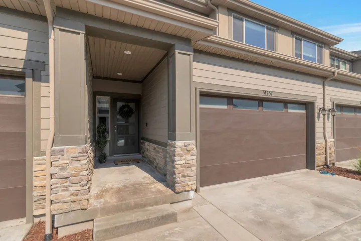 Entryway featuring a covered porch, a privacy glass door with vertical panels, and stone veneer accents