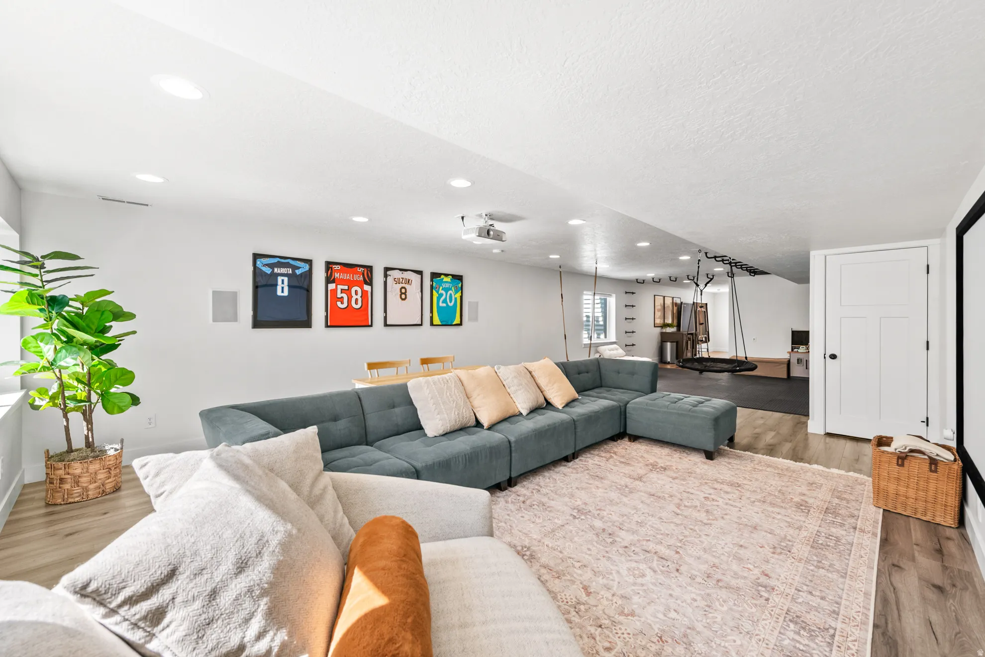Spacious entertainment area with recessed lighting and light wood-finish flooring