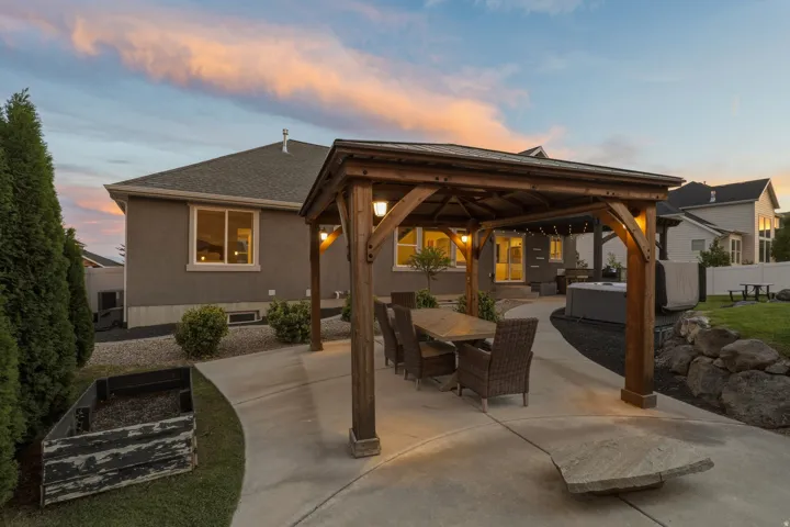 Expansive concrete patio featuring a wood-frame pergola with integrated lighting