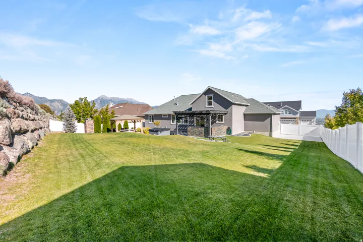 Expansive green lawn with a white privacy fence
