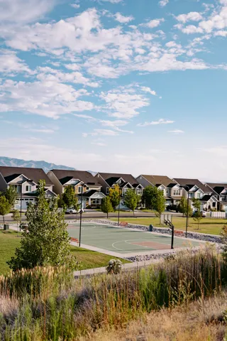Community basketball court featuring a light green surface and integrated seating