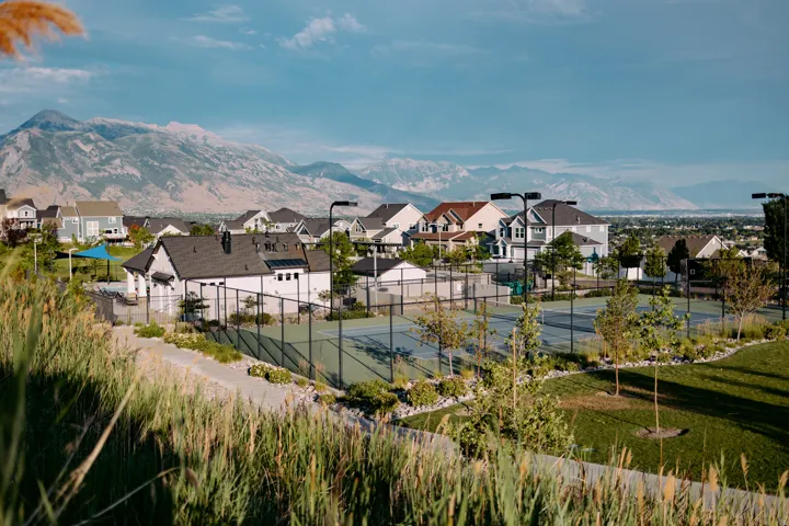 Community amenities featuring multiple tennis courts, manicured landscaping, and a clubhouse structure