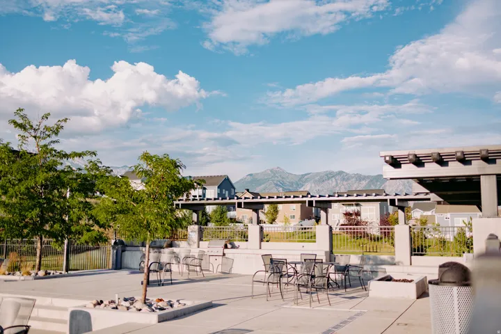Outdoor patio area featuring concrete paving, built-in grill stations, a fire pit, and a pergola