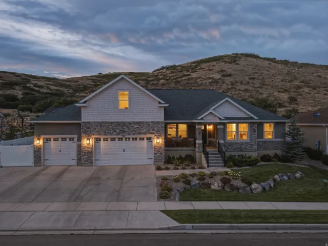 Stone and siding exterior with a multi-car driveway and an integrated garage