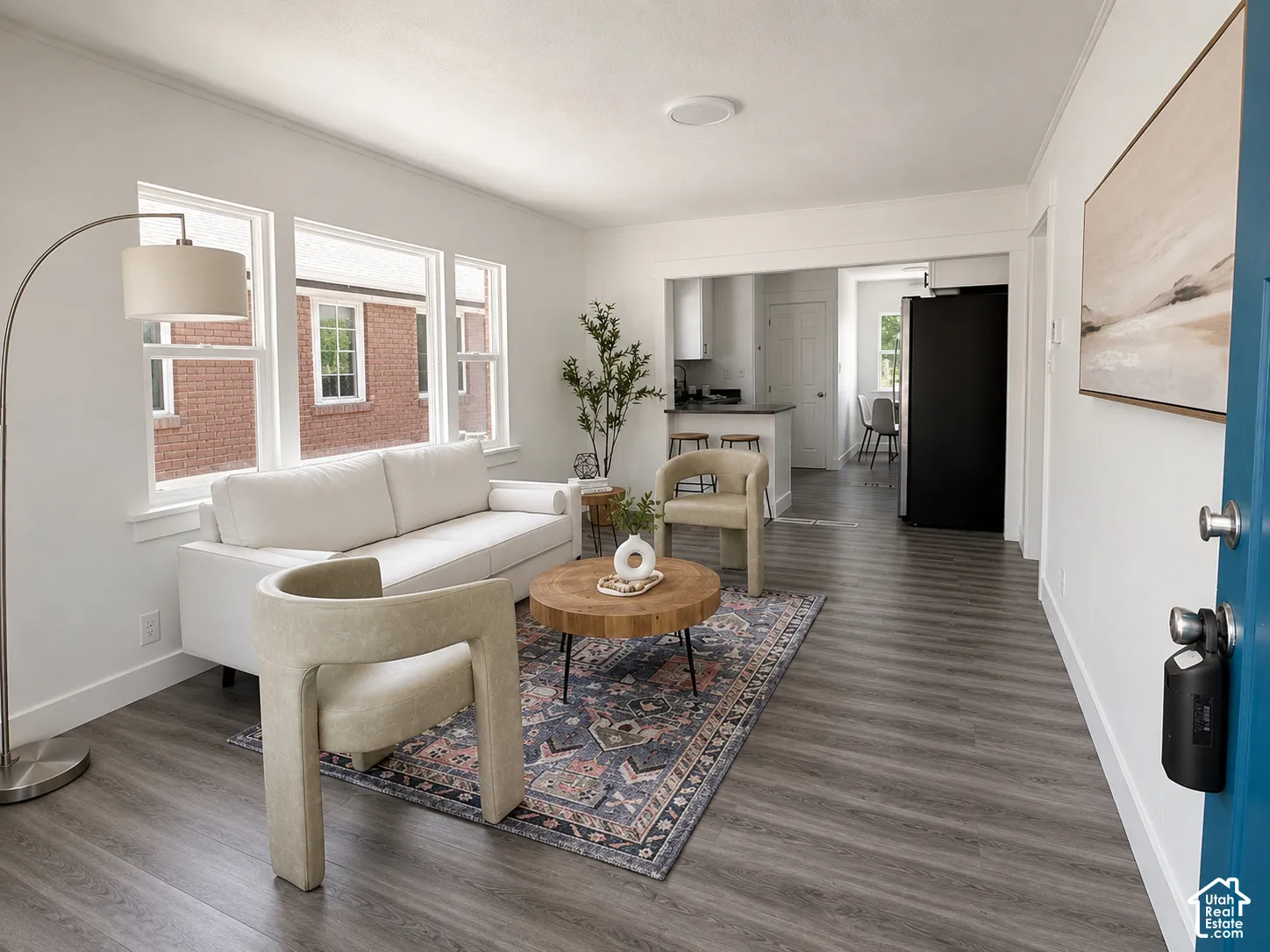 Bright living area with wood-finish flooring, white walls, and a recessed ceiling light