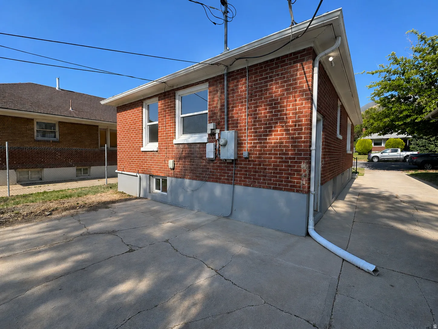 Brick exterior with a partial concrete driveway and a full concrete pad