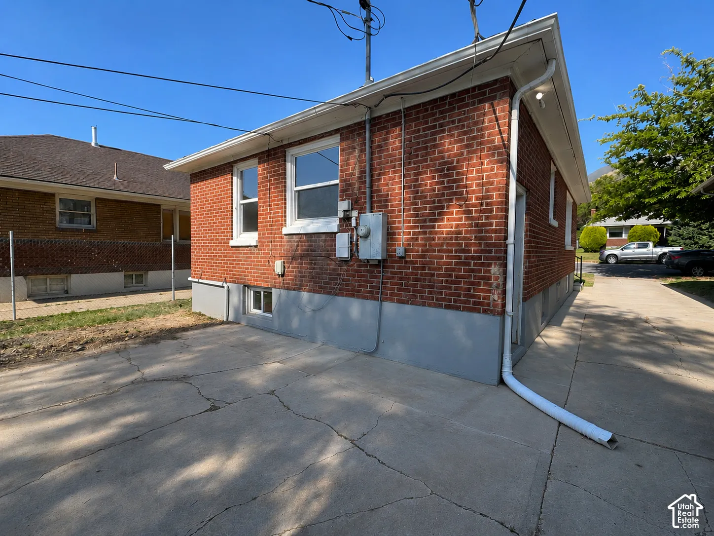 Brick exterior with a partial concrete driveway and a full concrete pad