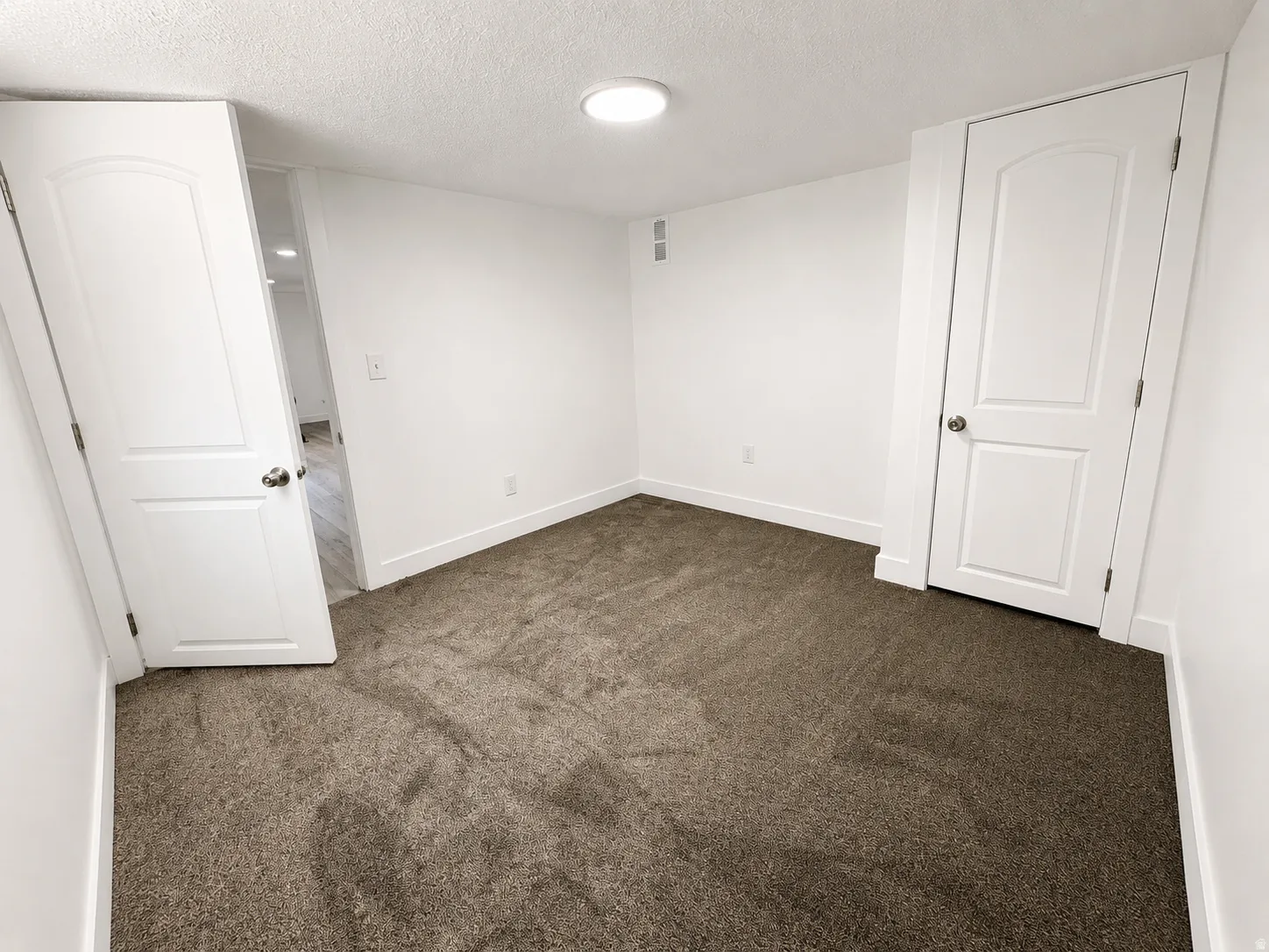 Neutral tone carpeting with white baseboards
