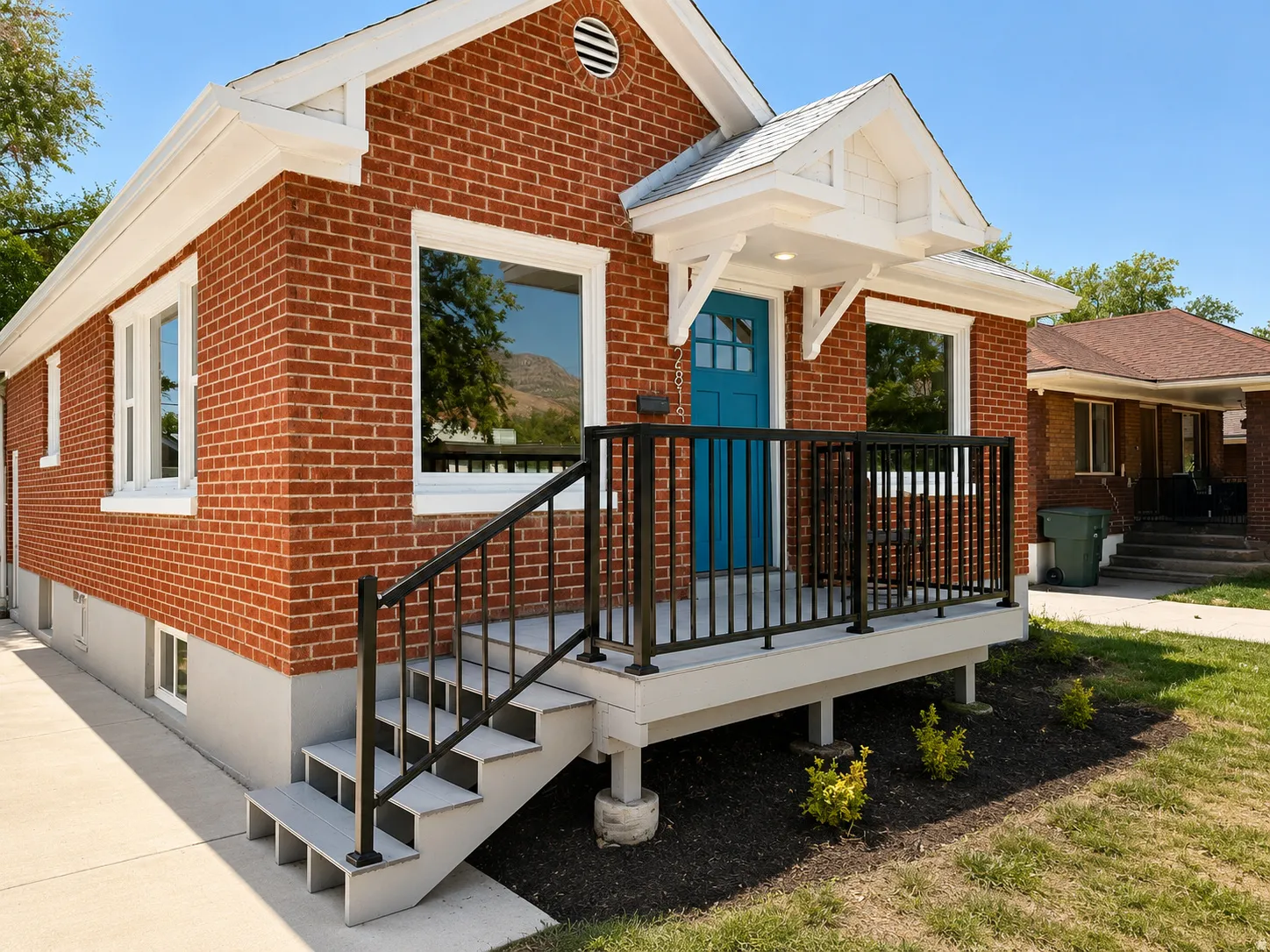 Brick exterior featuring white trim and a vibrant blue entry door