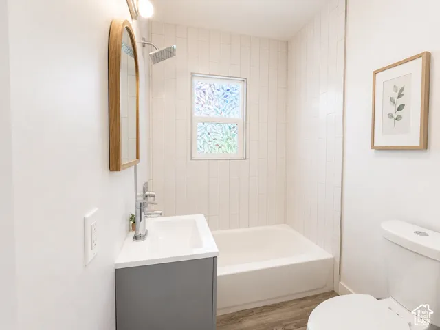 Bathroom featuring a white subway tile shower surround, showerhead with extended arm, and a window with decorative privacy film