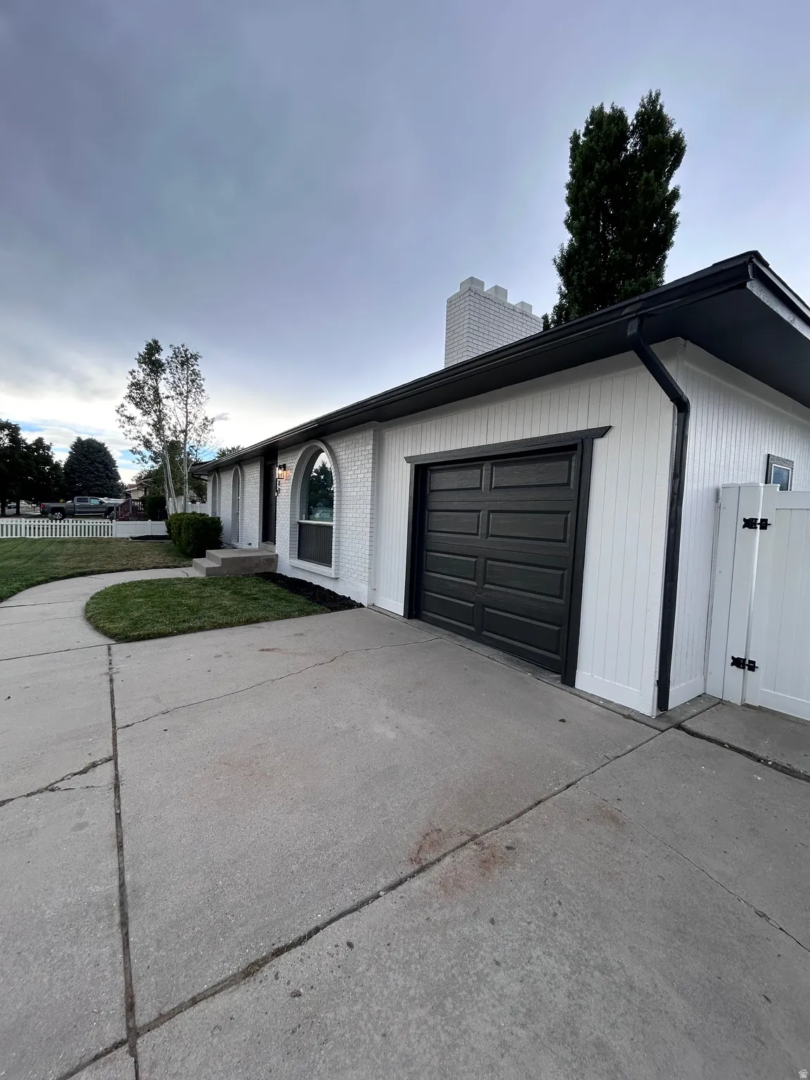 White brick and vertical siding exterior with contrasting black trim