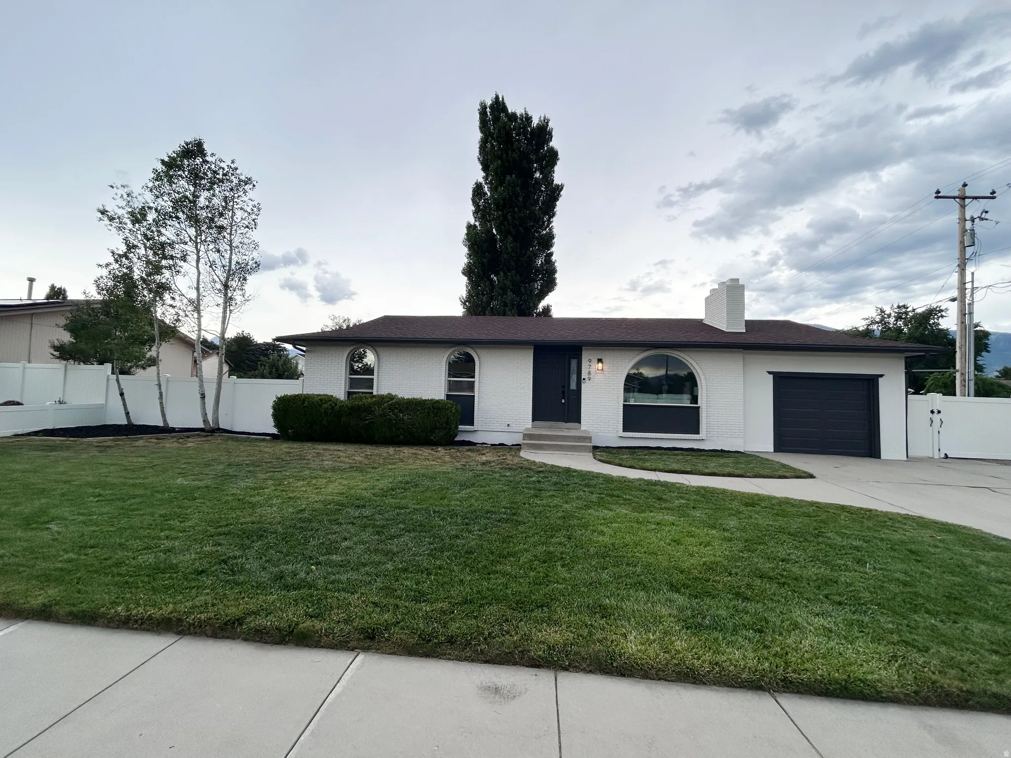White brick exterior with dark trim and arched windows