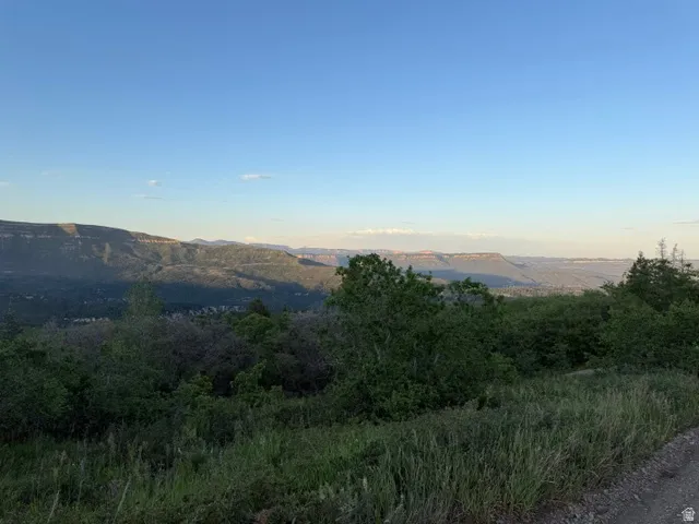 Expansive natural landscape featuring distant mountain ranges and a clear sky