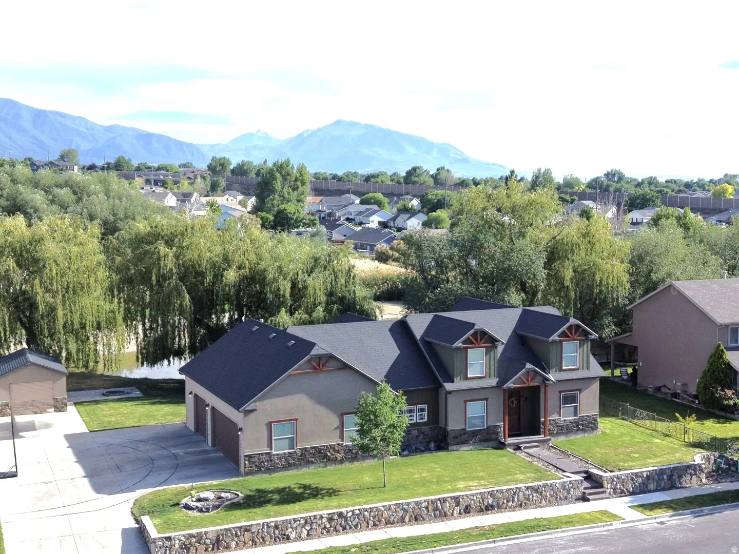 Contemporary residence featuring a multi-gable roofline and stone façade accents