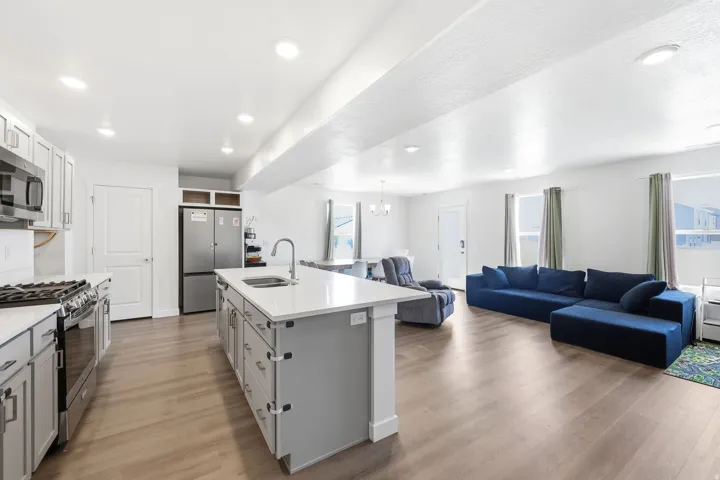Open-concept living area featuring wood-finish flooring, recessed lighting, and white walls