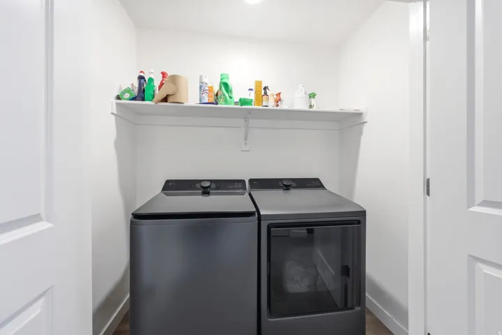 Dedicated laundry area featuring a white wall shelf, recessed lighting, and wood-finish flooring
