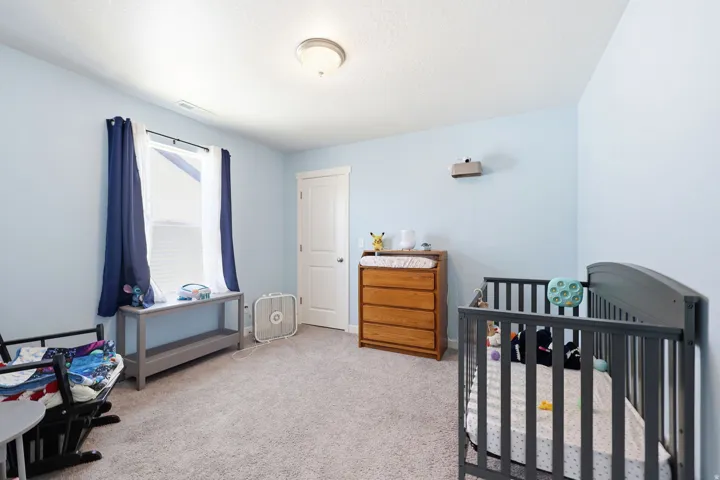 Room featuring light blue walls, a textured ceiling, and neutral carpet flooring
