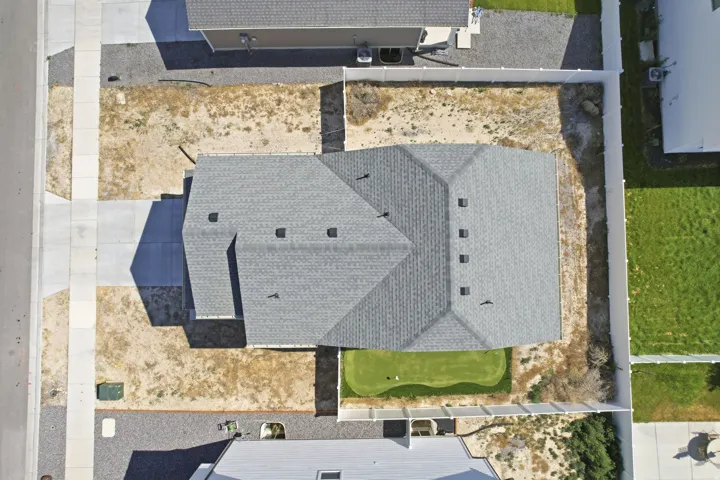 Property featuring a gray shingle roof, a concrete driveway, and a white perimeter fence