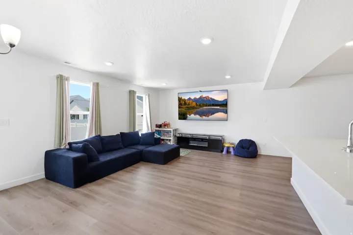Open living space featuring wood-finish flooring and recessed lighting