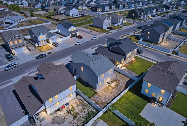 Newly constructed residential neighborhood featuring contemporary homes with dark shingle roofs and light-colored siding