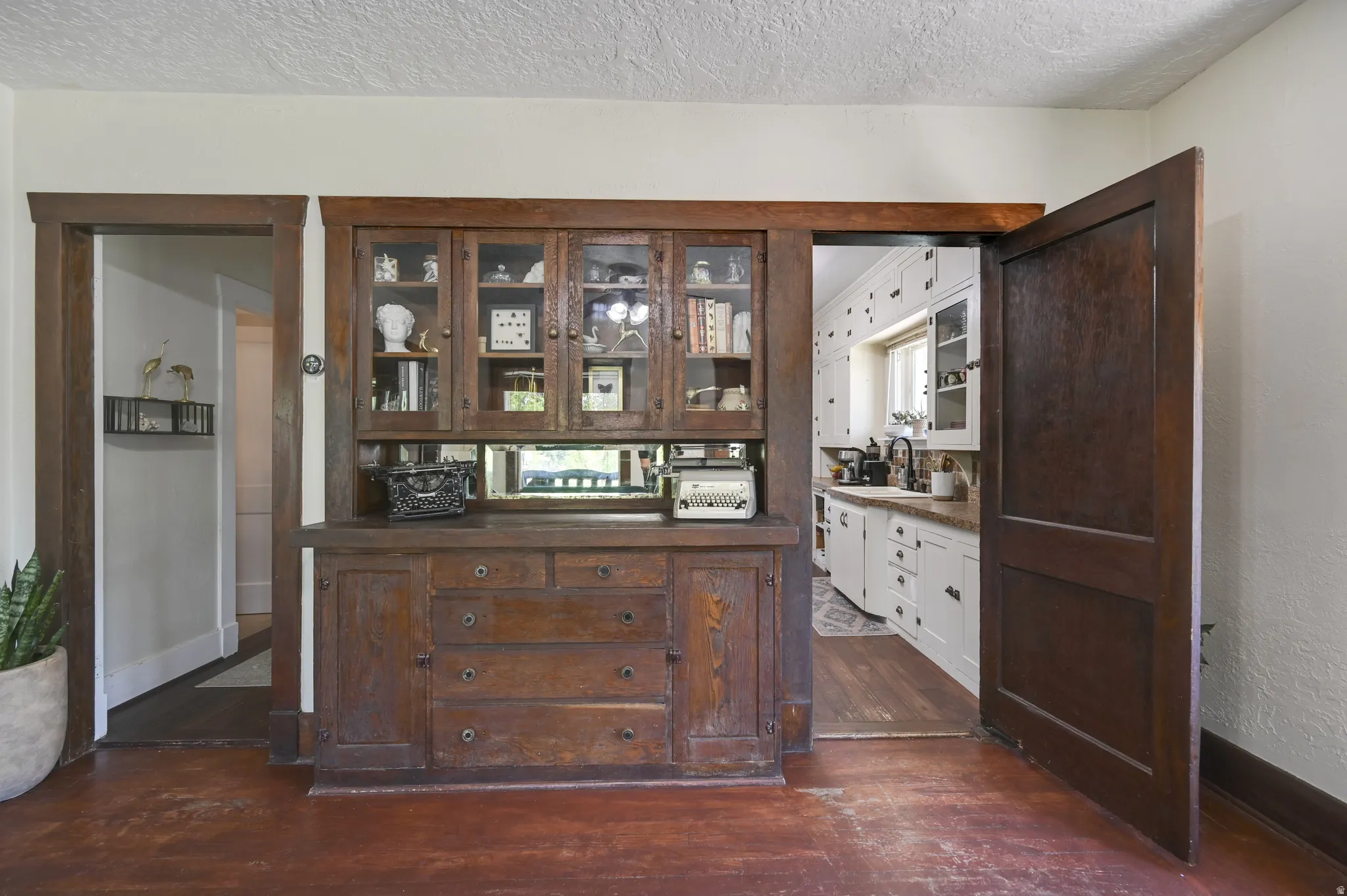 Built-in wood cabinetry featuring glass-front display cabinets, mirrored backsplash, and storage drawers